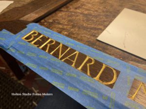 Carved lettering being gilded—Bernard Maybeck