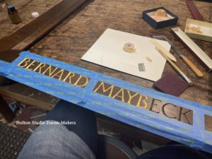 Carved lettering being gilded—Bernard Maybeck