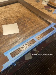 Carved lettering being gilded—Bernard Maybeck